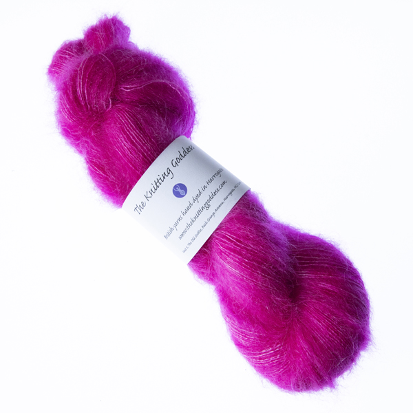 Raspbery hand dyed fluffy mohair silk yarn in a skein with The Knitting Goddess ball band