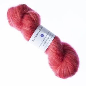 Red hand dyed fluffy mohair silk yarn in a skein with The Knitting Goddess ball band