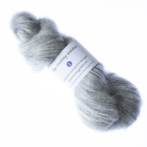 Silver hand dyed fluffy mohair silk yarn in a skein with The Knitting Goddess ball band