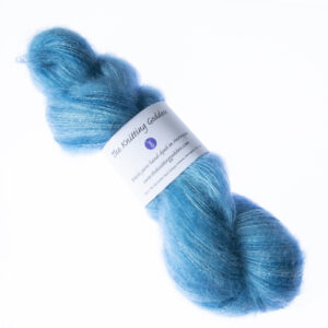 Teal hand dyed fluffy mohair silk yarn in a skein with The Knitting Goddess ball band