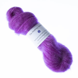 PInkish Purple hand dyed fluffy mohair silk yarn in a skein with The Knitting Goddess ball band