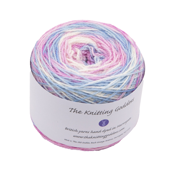 A yarn cake with The Knitting Goddess ball band. Yarn is hand dyed in pale, blue, pink and white of the Transsexual Pride Flag