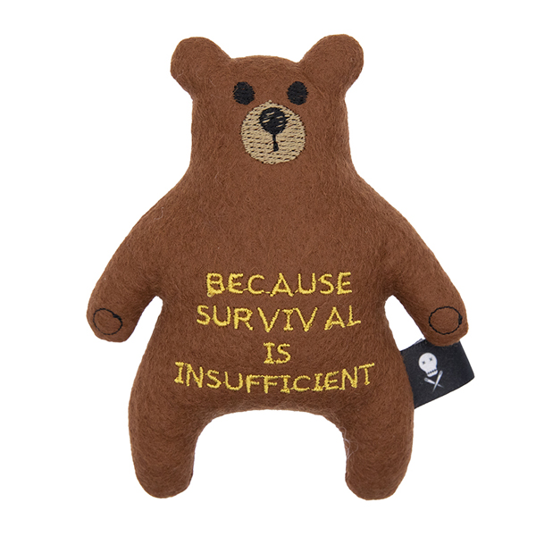 brown felt bear embroidered with the text "BECAUSE SURVIVAL IS INSUFFICIENT"
