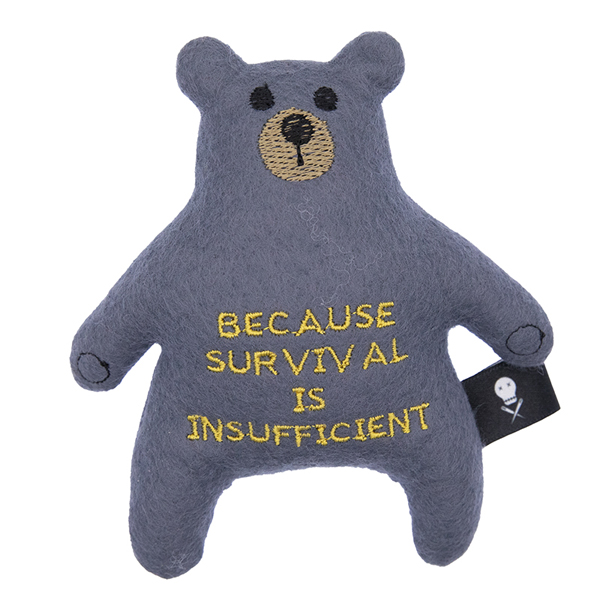 charcoal felt bear embroidered with the text "BECAUSE SURVIVAL IS INSUFFICIENT"