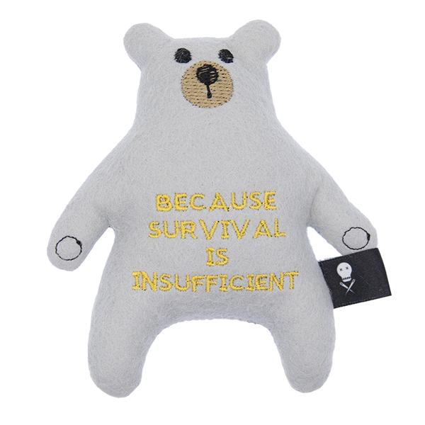 silver felt bear embroidered with the text "BECAUSE SURVIVAL IS INSUFFICIENT"