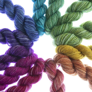 close up 12 mini skeins hand dyed in bright colours to make a printer ink colour wheel