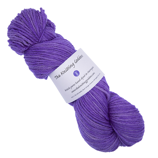 skein of purple hand dyed DK weight wool yarn with The Knitting Goddess ball band