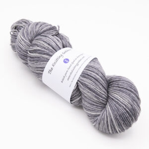 skein of hand dyed light grey yarn with The Knitting Goddess label