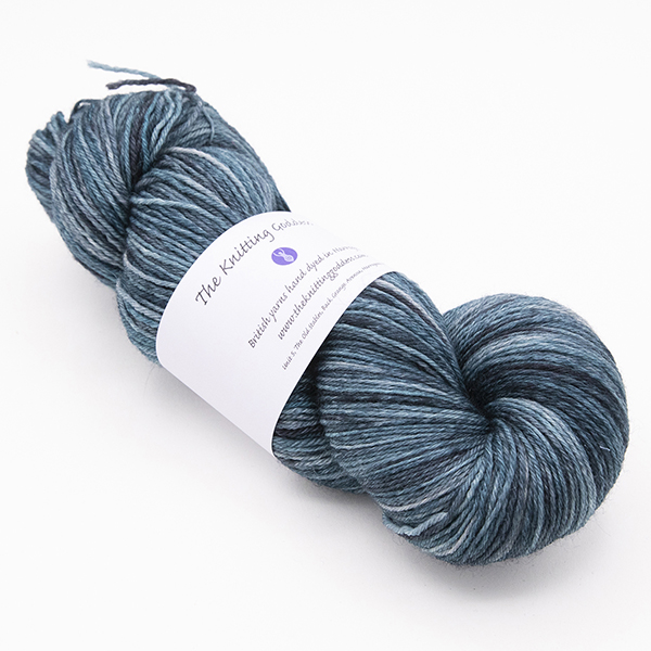 skein of hand dyed blackened turquoise yarn with The Knitting Goddess label