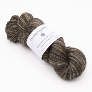 skein of hand dyed blackened walnut brown yarn with The Knitting Goddess label