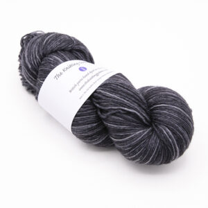 skein of hand dyed coal grey yarn with The Knitting Goddess label