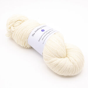 skein of hand dyed cream yarn with The Knitting Goddess label