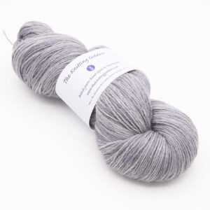 skein of hand dyed silver yarn with The Knitting Goddess label
