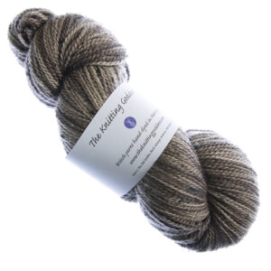skein of hand dyed brown tweed yarn with The Knitting Goddess label