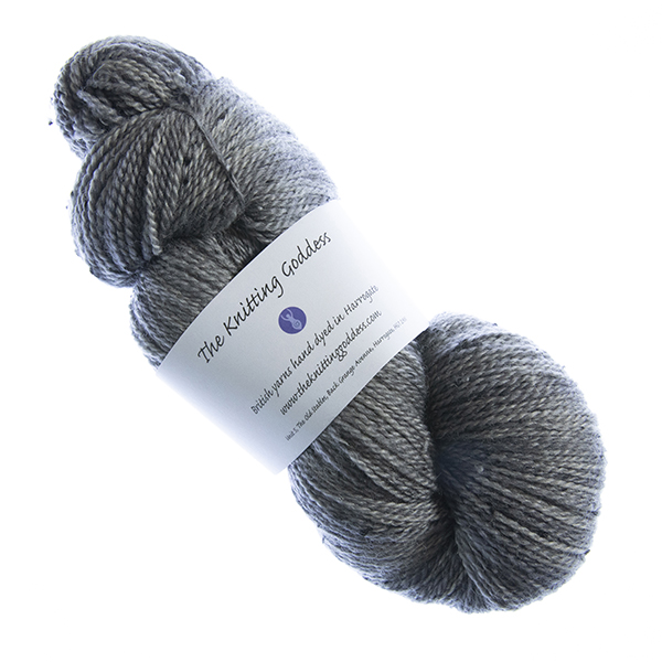 skein of hand dyed charcoal tweed yarn with The Knitting Goddess label