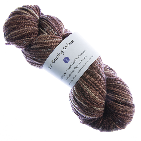 skein of hand dyed dark copper tweed yarn with The Knitting Goddess label