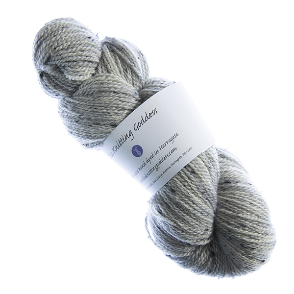 skein of hand dyed pale grey tweed yarn with The Knitting Goddess label