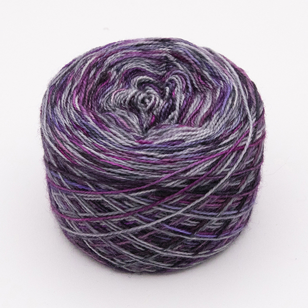 ball of self striping sock yarn with purples, plums and silver