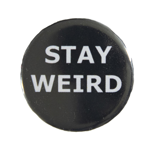 black pin badge with text "STAY WEIRD"
