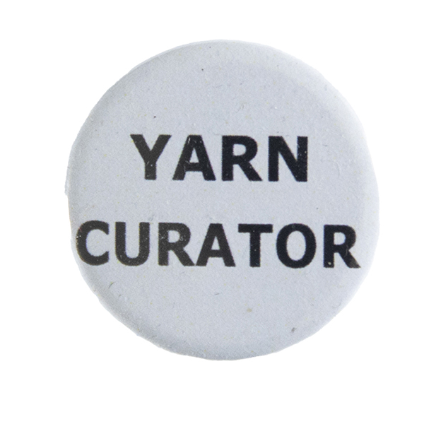 grey pin badge with text "YARN CURATOR"