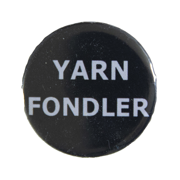 black pin badge with text "YARN FONDLER"