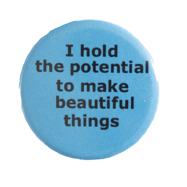 blue pin badge with text "I hold the potential to make beautiful things"