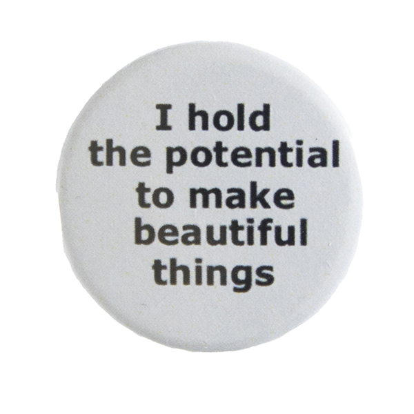 grey pin badge with text "I hold the potential to make beautiful things"
