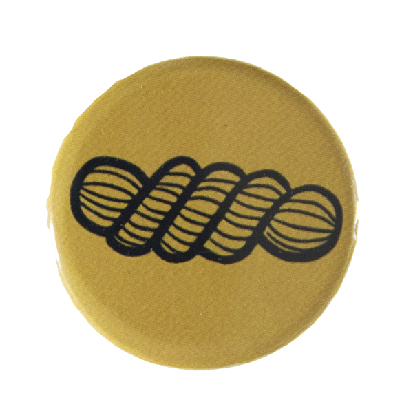 yellow pin badge with line drawing of a skein of yarn