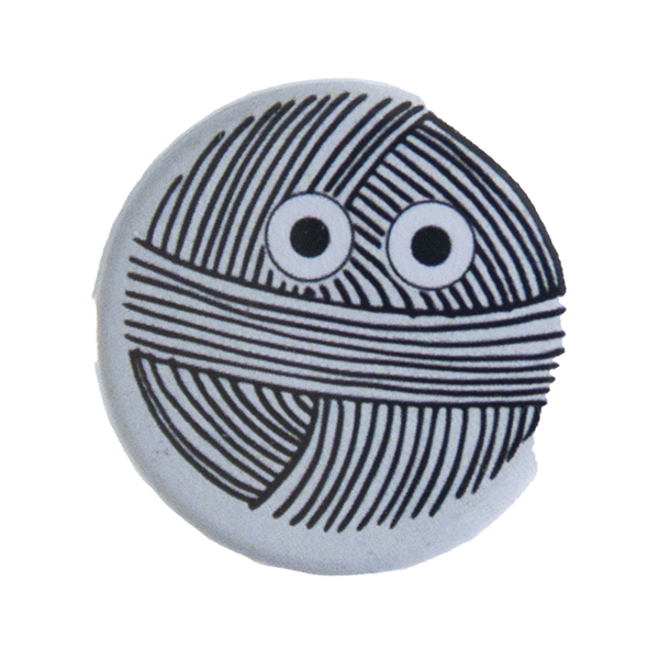grey pin badge with line drawing of a ball of yarn with eyes