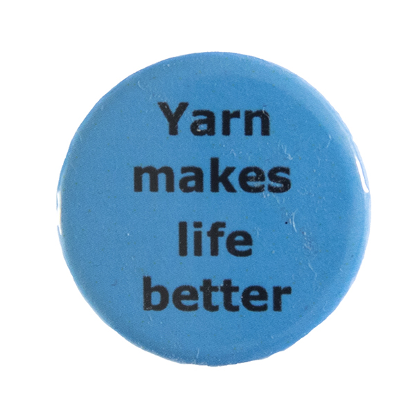 blue pin badge with text "Yarn makes life better"