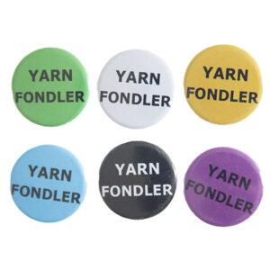 pin badges with text "YARN FONDLER". Badges are green, light grey, yellow. blue, black and pink