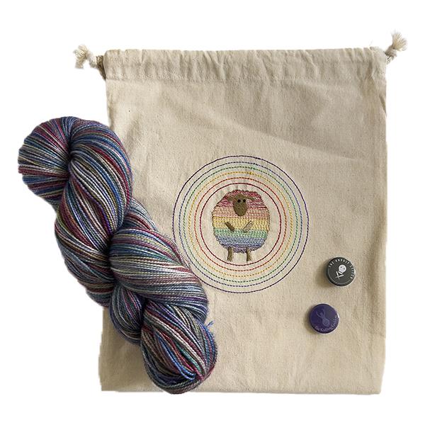 yarndale 2022 project bag with embroidered rainbow sheep project bag, skein of yarn in a tin of rainbows and badges from The Knitting Goddess and The Unruly Stitch