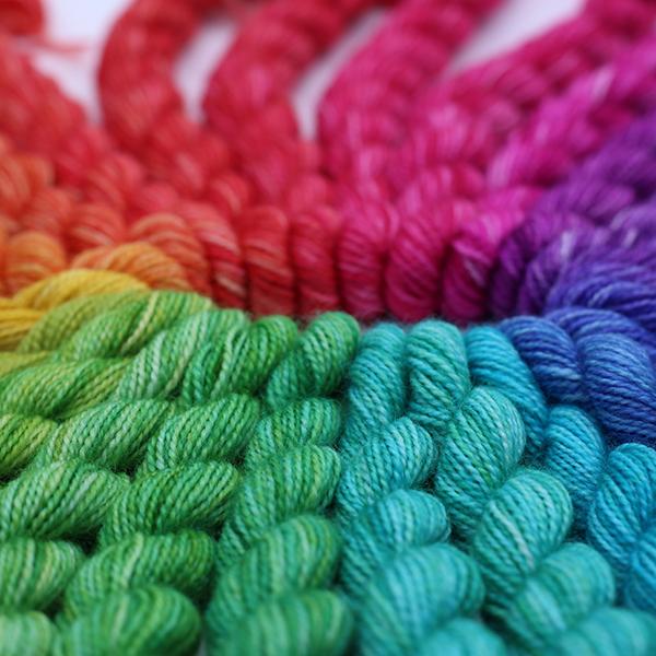 24 mini skeins making up a colour wheel. Photographed from a low angle so the view is along the skeins