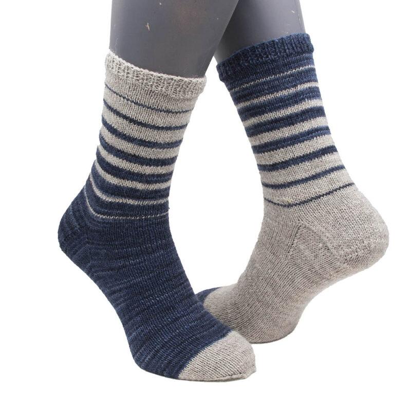 pair of hand knit striped socks in navy and pale silver. The colours re switched so one sock mirrors the other.