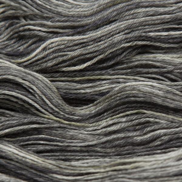 close up of hand dyed bluefaced leicester wool in blackened gold, a golden yellow overdyed with black
