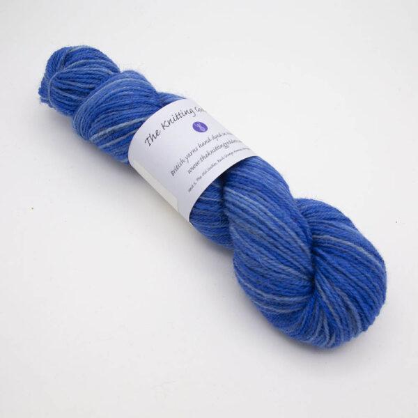 blue hand dyed sock yarn, wound up in a skein with The Knitting Goddess ball band
