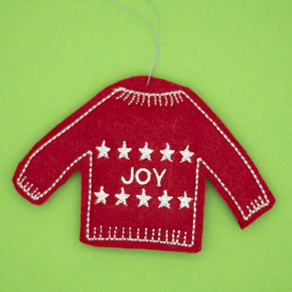 red christmas jumper decoration embroidered with two lines of white stars and the word JOY