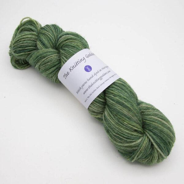 forest green hand dyed sock yarn, wound up in a skein with The Knitting Goddess ball band