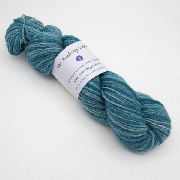 hydrangea hand dyed sock yarn, wound up in a skein with The Knitting Goddess ball band