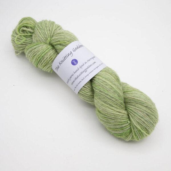 lime green hand dyed sock yarn, wound up in a skein with The Knitting Goddess ball band