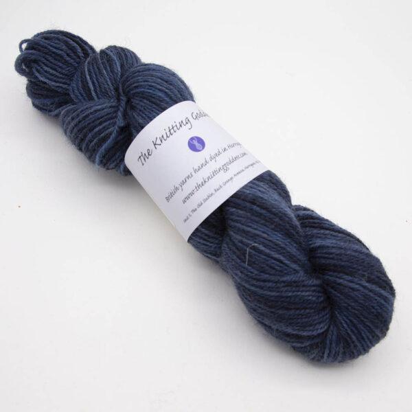 navy hand dyed sock yarn, wound up in a skein with The Knitting Goddess ball band