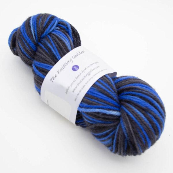skein of bigger on the inside DK sock wool dyed with blue and black with The Knitting Goddess ball band