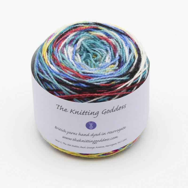 Candy is Dandy self striping sock yarn, red, pink, yellow, blue, turquoise, green, black and white. The yarn cake has The Knitting Goddess ball band.