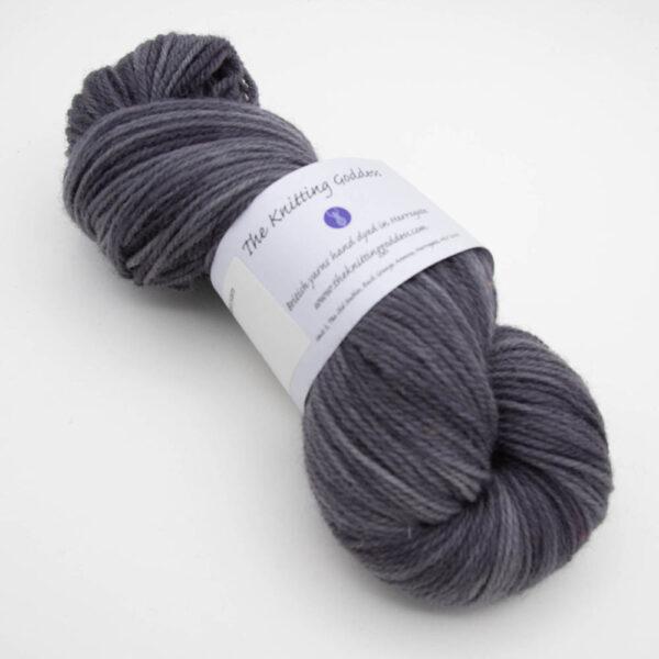 skein of charcoal (mid grey) DK sock wool with The Knitting Goddess ball band