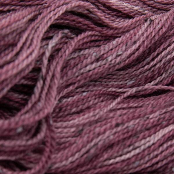 close up of dark red tweed yarn with dark flecks