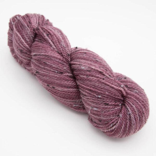skein of dark red tweed yarn with dark flecks