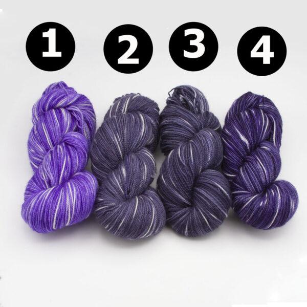 4 skeins of yarn in purples and greys with white flecks. Skeins are numbers 1 to 4
