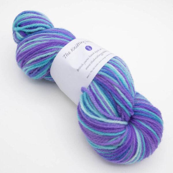 skein of kingfisher DK sock wool dyed with turquoise and purple with The Knitting Goddess ball band