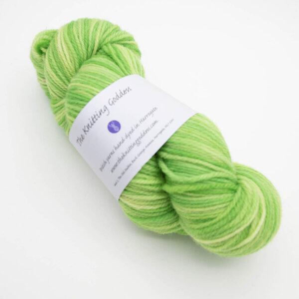 skein of lime green DK sock wool with The Knitting Goddess ball band