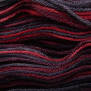 close up of menace DK sock wool dyed with red and black with The Knitting Goddess ball band